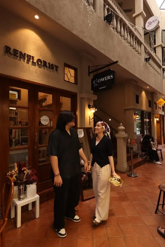 Addin and Umairah holding hands in front of a flower shop